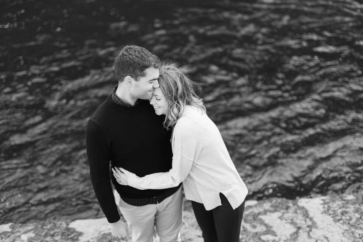 Les amoureux sont enlacés et souriant. Séance photo de couple au bord de la rivière.